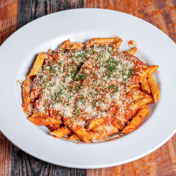 Penne pasta with red sauce, generously topped with grated Parmesan cheese and fresh parsley.