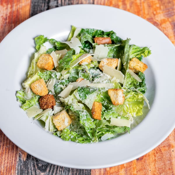 A Caesar salad from Kozi Italian Street Food, with crisp romaine, croutons, and Parmesan cheese.